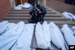 Palestinians mourn their relatives killed in the Israeli bombardment of the Gaza Strip, in the hospital in Khan Younis, Dec. 3, 2023.