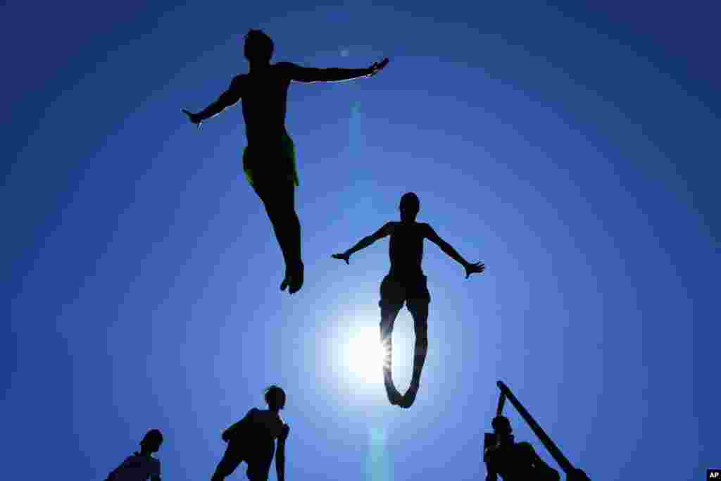 Young people jump into the water to cool down on a sweltering hot day at the Mediterranean Sea in Beirut, Lebanon.