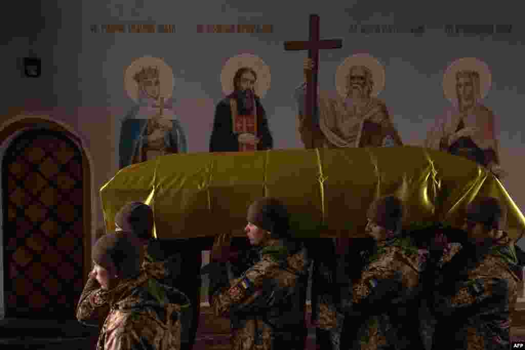 Ukrainian servicemen carry a coffin of a Ukrainian poet and serviceman Maksym Kryvtsov who was killed fighting Russian troops, at the Saint Michael&#39;s Golden-Domed Monastery in Kyiv.