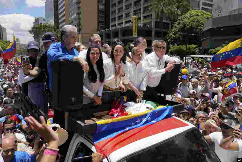 Maria Corina Machado, center, leads a protest against the reelection of President Nicolás Maduro one month after the disputed presidential vote which she claims the opposition won by a landslide, in Caracas, Venezuela.