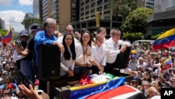 Maria Corina Machado, center, leads a protest against the reelection of President Nicolás Maduro one month after the disputed presidential vote which she claims the opposition won by a landslide, in Caracas, Venezuela.