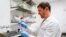 Research scientist Kevin Potts checks on trypsin, a proteolytic enzyme, to dissociate ovarian cancer cells being grown on a plastic plate at UW Medicine's Cancer Vaccine Institute May 25, 2023.