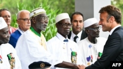 Le président français Emmanuel Macron salue des anciens combattants africains lors de la cérémonie du 80e anniversaire du débarquement de Provence.