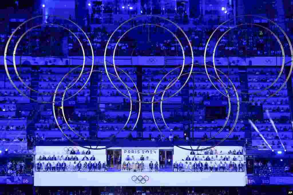 The audience watches behind suspended Olympic rings during the 2024 Summer Olympics closing ceremony at the Stade de France, in Saint-Denis, France, Aug. 11, 2024.