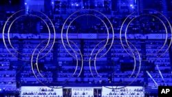 The audience watches behind suspended Olympic rings during the 2024 Summer Olympics closing ceremony at the Stade de France, in Saint-Denis, France, Aug. 11, 2024.