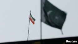 The flag of Iran is seen over its consulate building, with Pakistan's flag in the foreground, in Karachi, Pakistan, Jan. 18, 2024. 