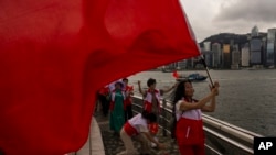 资料照片：北京支持者举着中国旗帜庆祝香港归回中国统治26周年。(2023年7月1日)