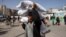 FILE — A man carries bags of humanitarian aid in Rafah in the southern Gaza Strip, Nov. 26, 2023. The United States on Tuesday sent the first of three military planes to Egypt with humanitarian aid for Gaza.