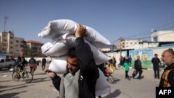 A man carries away bags of humanitarian aid in Rafah in the southern Gaza Strip, Nov. 26, 2023. 