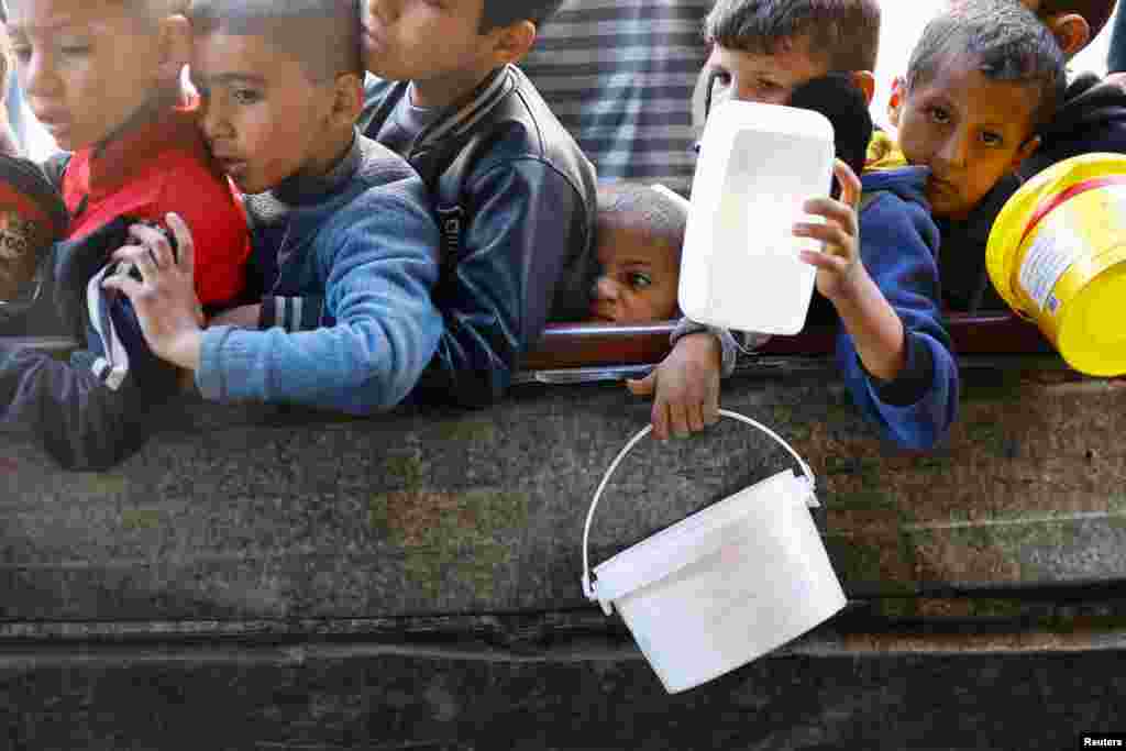 Palestinian children wait to receive food amid shortages of food supplies in Rafah in the southern Gaza Strip.