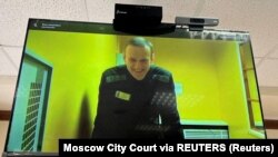 Pemimpin oposisi Rusia Alexei Navalny terlihat di layar melalui tautan video dari penjara selama sidang pendahuluan di Pengadilan Kota Moskow di Moskow, Rusia, 31 Mei 2023. (Foto: Pengadilan Kota Moskow via REUTERS)