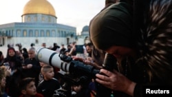 Members of the Palestinian Astronomical Society and Waqf team use a telescope to look for a crescent moon ahead of the Muslim holy month of Ramadan, at Al-Aqsa compound, known to Jews as Temple Mount, in Jerusalem's Old City, March 10, 2024.
