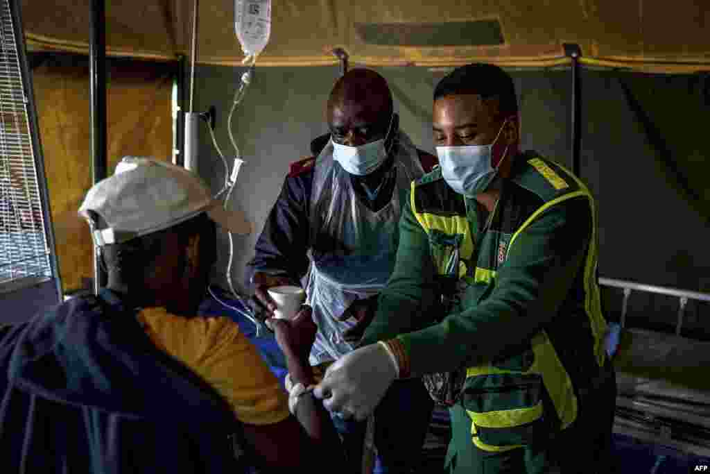 A patient is given water as he receives treatment at a field hospital in Kanana, Hammanskraal.&nbsp;An outbreak of cholera has killed at least 23 people near South Africa&#39;s capital of Pretoria, as city officials urged those who live in Hammanskraal and surrounding areas not to drink tap water.