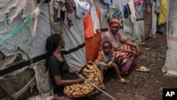 People sit at the Don Bosco refugee camp as Red Cross officials create awareness around mpox in Goma, Democratic Republic of Congo, Aug. 22, 2023. 