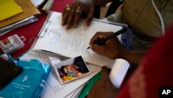 Upendra Ram signs a paper to receive body of his son who died in Friday's train accident in Balasore, at the All India Institute of Medical Sciences hospital in Bhubaneswar in the eastern state of Orissa, June 5, 2023.