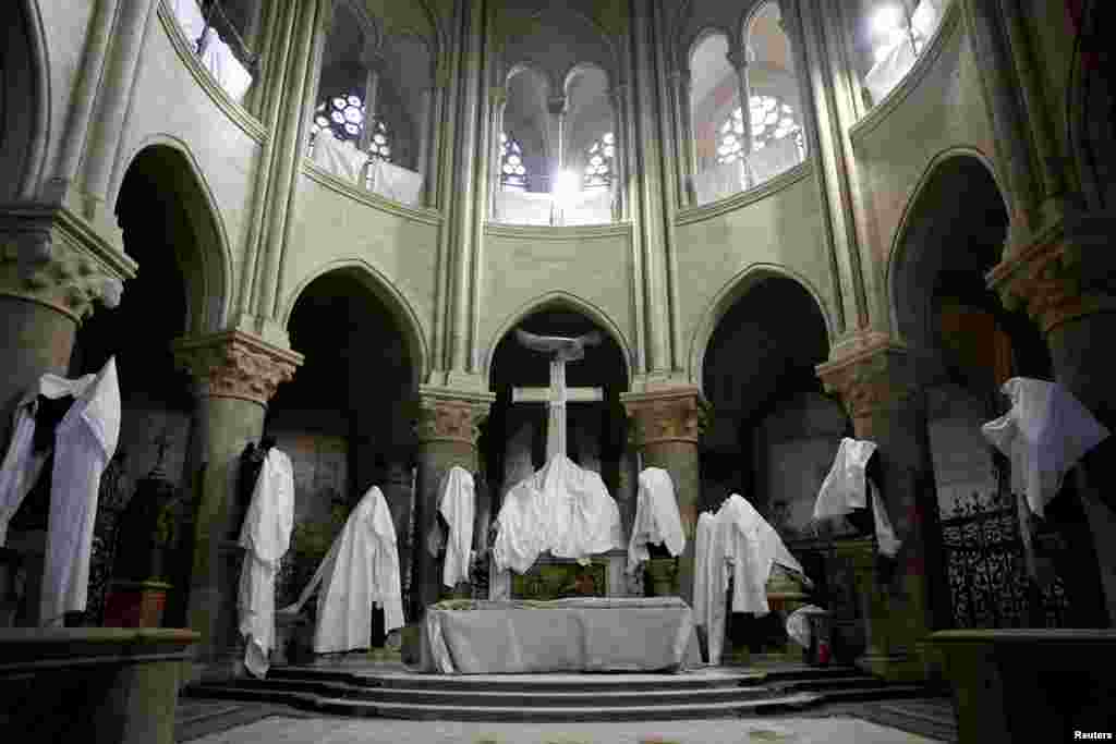 Statues protected by tarpaulins are seen in the choir of the Notre-Dame de Paris Cathedral, which was ravaged by a fire in 2019 that sent its spire crumbling down, as restoration works continue a year before its reopening to the public, in Paris, France.