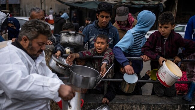 Palestinezët qëndrojnë në rradhë për ushqim në Rafah, në Rripin e Gazës, 23 shkurt, 2024.