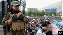 A Taliban fighter and Afghan people pray during Eid al-Adha, in Kabul, Afghanistan, June 28, 2023. The Taliban ordered, July 11, 2023, the suspension of all Swedish activities in Afghanistan because of the public burning of the Quran at a protest in Sweden last month.
