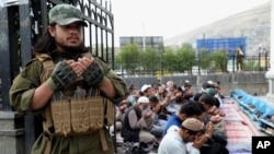 Seorang pejuang Taliban dan warga Afghanistan melakukan salat Iduladha, di Kabul, Afghanistan, 28 Juni 2023. Taliban memerintahkan penangguhan semua kegiatan Swedia di Afghanistan, 11 Juli 2023, karena aksi pembakaran Al-Qur'an di depan umum di Swedia bulan lalu.