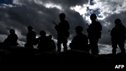 Ukraine Army recruits stand above a trench as they wait to take part in a trench warfare training session with members of New Zealand's armed forces personnel at a British Ministry of Defense training base in southern England, March 27, 2023.