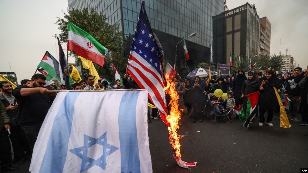 Para pedemo membakar bendera Israel dan AS dalam unjuk rasa di luar gedung bekas Kedutaan Besar AS di Teheran, iran, Sabtu, 4 November 2023. (Foto: Atta Kenare/AFP)