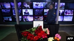 Flowers are left in front of a portrait of Boris Maksudov, a military correspondent for the Rossiya 24 TV channel who died from injuries sustained in a drone attack in Ukraine, at the entrance to VGTRK headquarters in Moscow, Nov. 23, 2023.