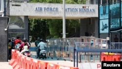 People wait to get inside the Indian Air Force's Hindon Airbase in Ghaziabad, India, where Sheikh Hasina landed on Aug. 5 after she resigned as the prime minister of Bangladesh and fled the country following a violent uprising against her rule, Aug. 6, 2024. 