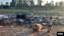 A child plays at pile of garbage in Harare, Zimbabwe, on Jan. 17, 2024. Observers say uncollected refuse is one of the causes fueling an outbreak of cholera in Zimbabwe and other African nations. (Columbus Mavhunga/VOA)