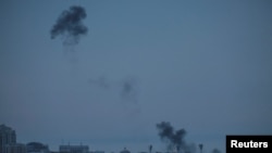 Smoke rises over the city after the remains of a shot-down drone landed on the ground, amid Russia's attack on Ukraine, in Kyiv, May 4, 2023. 