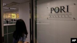 香港民意研究所的一名雇员走进大门。（2023年6月21日）