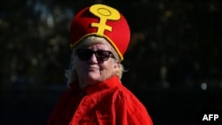 FILE - A supporter of Women's Ordination Conference (WOC), dressed as a Pope with red vestments, takes part in a demonstration to advocate and pray for the ordination of women, near the Vatican in Rome on Oct. 6, 2023.