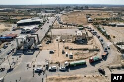 This aerial view shows humanitarian aid trucks crossing into the Palestinian side of the Rafah border crossing with northeastern Egypt's North Sinai province, in the southern Gaza Strip, Oct. 21, 2023.