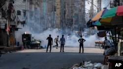 (FILE) Police fire tear gas shells to disperse garment factory workers who were blocking traffic demanding better wages in Bangladesh.