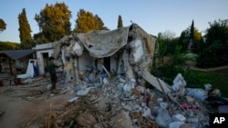 An Israeli soldier inspects a house damaged by Hamas militants in Kibbutz Kfar Azza, Israel, Nov. 5, 2023. The kibbutz was overrun by Hamas militants from the nearby Gaza Strip on October 7, when they killed and captured many Israelis.