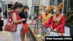 Indonesian women serve tea to visitors in front of their country's pavilion in Dubai, United Arab Emirates, on Dec. 6, 2023.