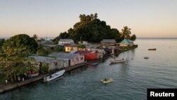 FILE - The morning's first rays of sunlight hit the island community of Serua Village, Fiji, July 15, 2022. Rising sea levels are a growing threat to such island villages. 