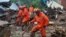 Firefighters take part in a search and rescue operation at landslide caused by torrential rain in Yecheon, South Korea, July 15, 2023. (Yonhap via Reuters)
