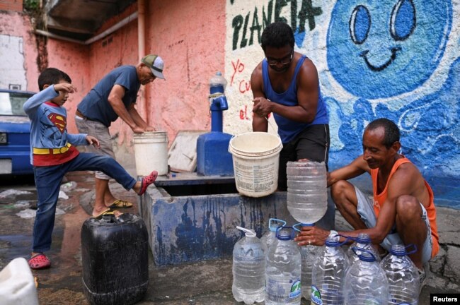 FILE - People extract water from an unknown source in the low-income neighborhood of Petare, in Caracas, Venezuela May 12, 2023. (REUTERS/Gaby Oraa)