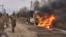 In this photo provided by Ukraine's military, Ukrainian soldiers pass by a bus burning after a Russian drone hit it near Bakhmut, Donetsk region, Ukraine, Nov. 23, 2023.