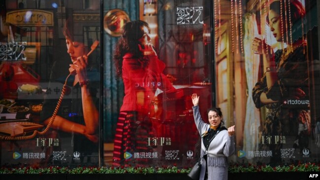 一名女子在电视剧《繁花》剧照前留影。(2024年1月7日)