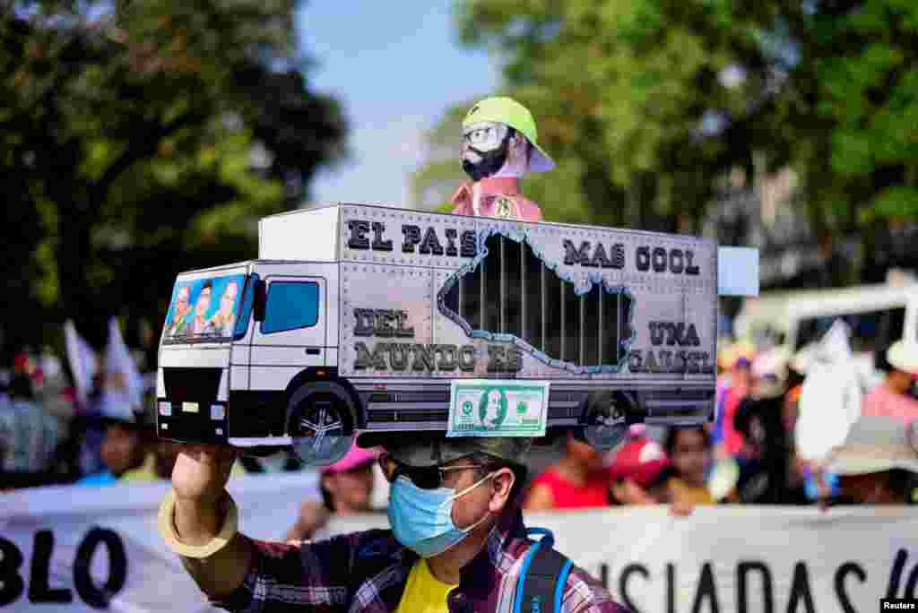 Un hombre sostiene un cartel con un mapa de El Salvador simulando una prisión durante una protesta para conmemorar el 32&ordm; aniversario de la firma del Acuerdo de Paz que puso fin a la Guerra Civil en El Salvador.