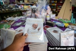 Boneka dan buku Paus Fransiskus dijual di Gereja Santo Antonius Padua, Yogyakarta, pada 2 September 2024, sebagai persiapan menyambut kedatangan Paus ke Indonesia. (Foto: AFP/Devi Rahman)