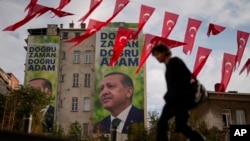 A man walks past billboards displaying Turkish President Recep Tayyip Erdogan and read in Turkish: 'For the Turkish century, the right time, the right man' in Istanbul, Turkey, Nov. 3, 2023.