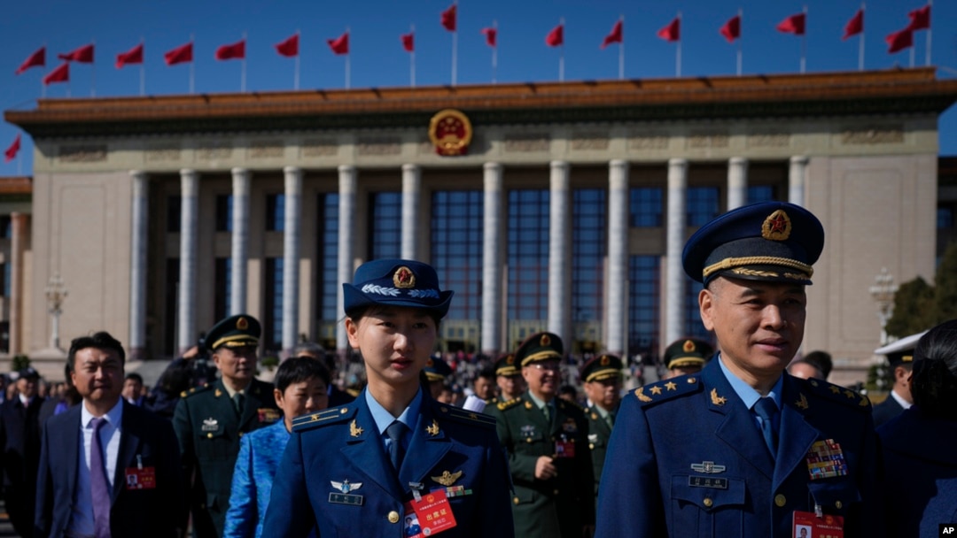Military officers and delegates leave the Great Hall of the People after attending the second plenary session of the National People's Congress (NPC) in Beijing, March 8, 2024.