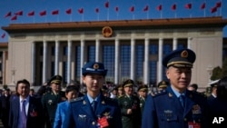 Military officers and delegates leave the Great Hall of the People after attending the second plenary session of the National People's Congress (NPC) in Beijing, March 8, 2024.