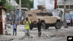 Youths raise their hands to show police they are not carrying weapons during an anti-gang operation in Port-au-Prince, Haiti, Feb. 29, 2024.