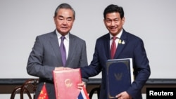 Chinese Foreign Minister Wang Yi, left, and Thai Foreign Minister Parnpree Bahiddha-Nukara shake hands during a signing ceremony of an agreement on mutual visa exemption, at the Ministry of Foreign Affairs in Bangkok, Thailand, Jan. 28, 2024.