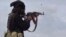 FILE - This image posted March 18, 2019, by the Amaq news agency shows an Islamic State fighter shooting at Syrian Democratic Forces in Baghouz, Syria. IS said on Nov. 10, 2023, that it had attacked pro-government forces in Syria in preceding days.
