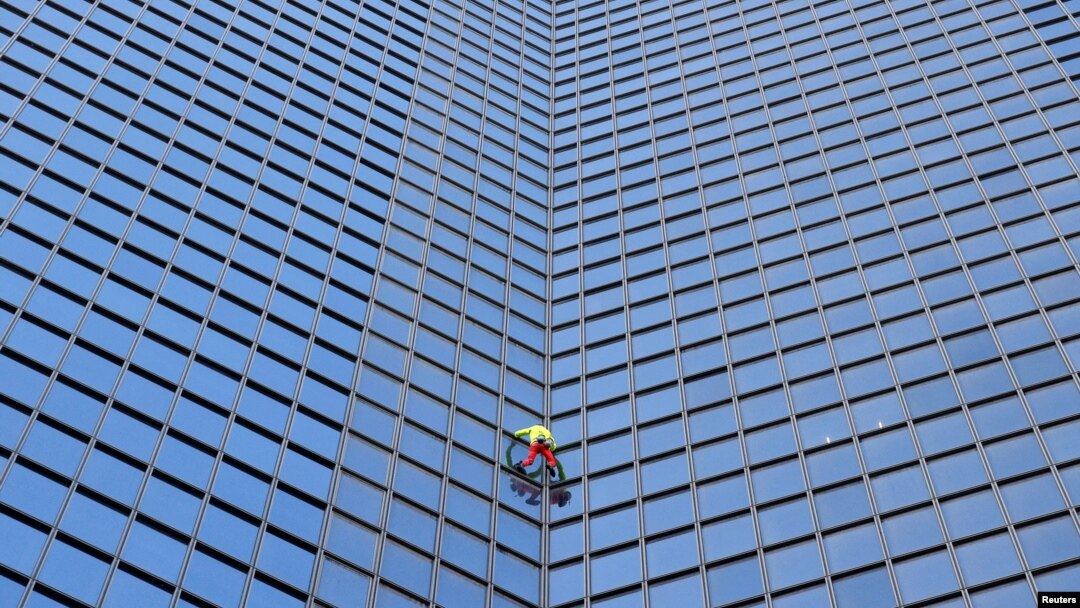 "Spiderman" Prancis Alain Robert memanjat gedung pencakar langit "Tour TotalEnergies Coupole" untuk menyerukan "Perdamaian di Timur Tengah" di Puteaux di distrik keuangan La Defense di Puteaux, dekat Paris, Prancis hari Senin (6/11). (Reuters) 