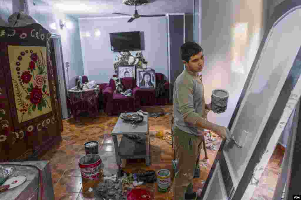 Unable to afford a professional painter to spruce up his family's home in time for Christmas, student Abanoub Samaan is determined to do it himself. Materials, he says, are also costly. Cairo, Egypt, Jan. 5, 2024. (Hamada Elrasam/VOA)